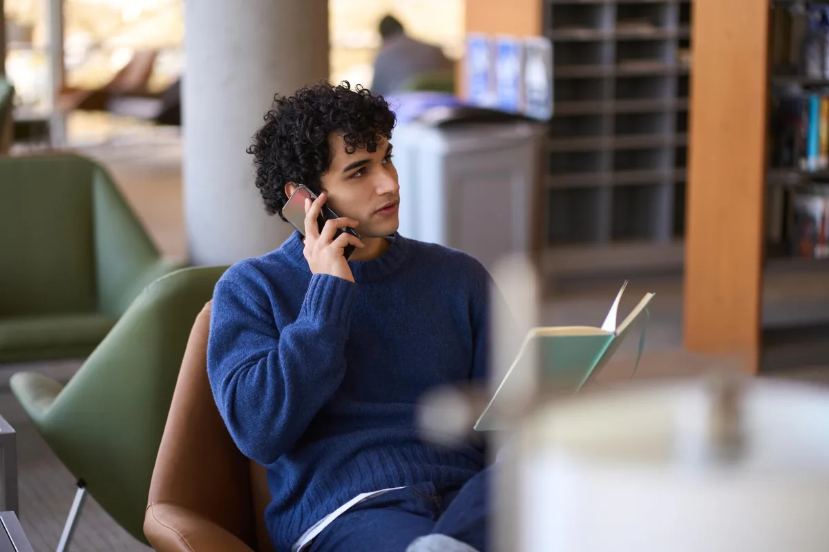 Person wartet am Telefon – eine Warteschleife, die nicht nervt