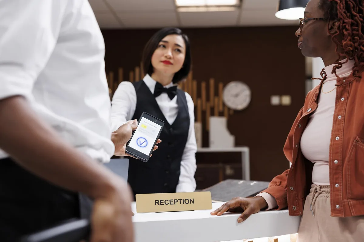 Hotelrezeption mit Mitarbeiterin – Telefonansage für Hotel und Gastronomie