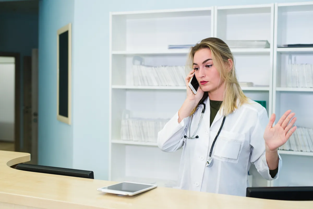 Ärztin am Telefon in der Praxis – Telefonansagen nach Branche